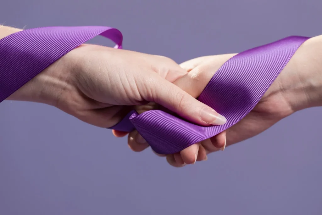 Deux mains entrelacées, reliées par un ruban enroulé autour d’elles.