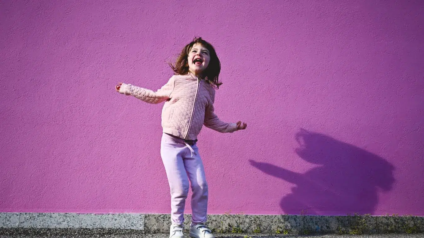Une jeune fille, le visage rayonnant, s’exclame avec joie.